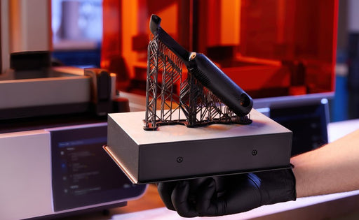 Formlabs Black Resin V.5 for Form 4 SLA 3D Printer | Image of person holding a Form 4 Build Platform with 3D printed part  in black resin